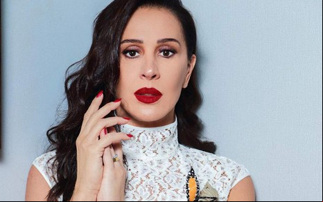 Claudia Raia com expressão séria, batom vermelho e vestido branco em foto publicada no Instagram