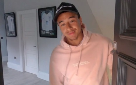 Jesse Lingard vestindo moletom rosa e boné, e abrindo a porta de sua mansão