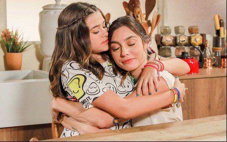 Julieta (Vittória Seixas) abraça Mariana (Juliana Schalch) em cena da novela