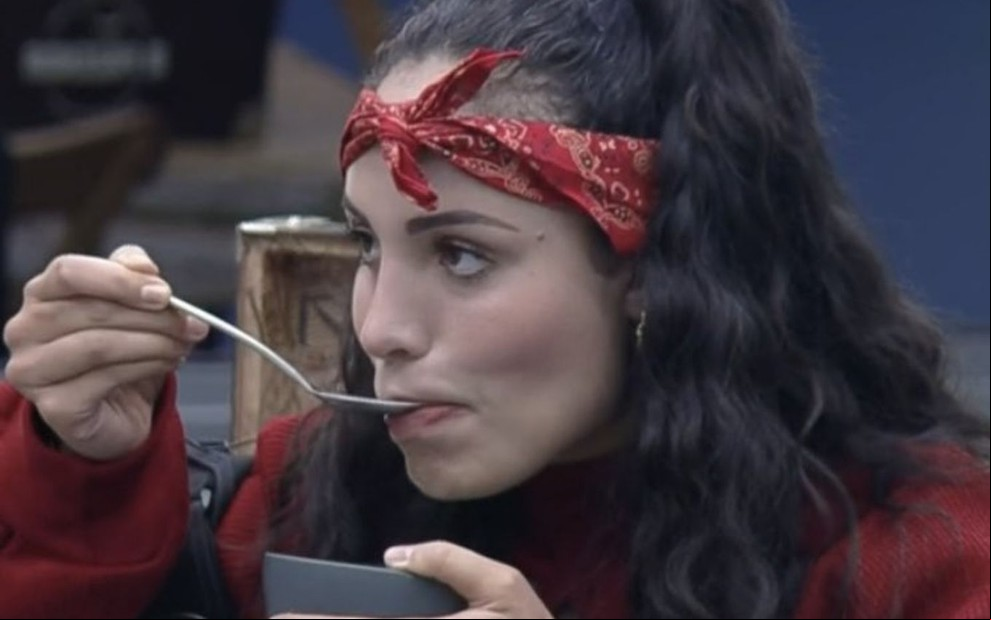 Imagem de Aline Mineiro de bandana vermelha comendo em A Fazenda 13