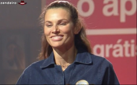 Dayane Mello veste macacão azul, sorriu e está com o cabelo preso