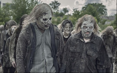 Okea Eme-Akwari e Lauren Cohan estão caracterizados como zumbis em uma horda de mortos-vivos de Walking Dead