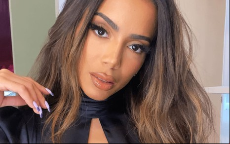 Anitta usa uma blusa preta e faz carão para a câmera