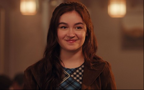 Anna Cathcart está com cabelos soltos e sorri