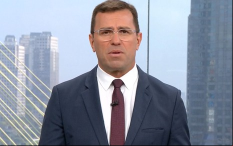 Rodrigo Bocardi com expressão séria e usando terno no cenário do Bom Dia São Paulo