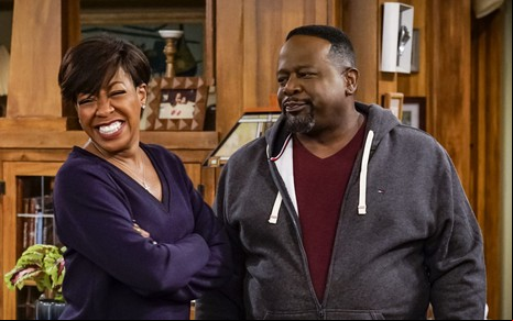 Tichina Arnold sorri forçadamente enquanto Cedric the Entertainer faz cara de desprezo em cena da série A Boa Vizinhança