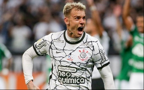 Roger Guedes comemora gol do Corinthians na Neo Quimica Arena. Ele beija o escudo e corre com uma chuteira laranja.