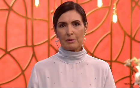 Fátima Bernardes de cabelo preso, com a franja de lado e blusa branca com brilhantes