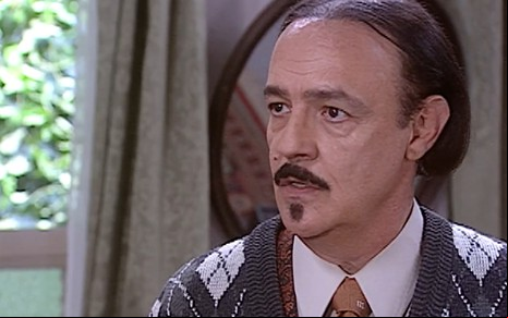 Ney Latorraca, caracterizado como Cornélio: bigode, cavanhaque fino e cabelos alisados na altura do queixo