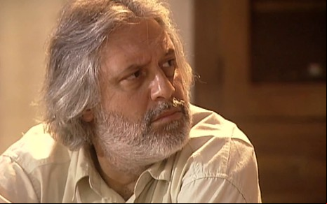 Antonio Fagundes caracterizado como Bruno Mezenga; ele veste uma camisa xadrez e tem o semblante abatido em cena de O Rei do Gado