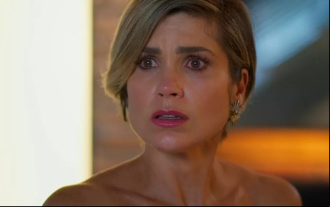 A atriz Flávia Alessandra, como Helena, personagem de Salve-se Quem Puder, com os olhos arregalados e expressão de surpresa