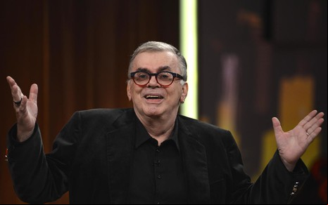 O autor Walcyr Carrasco com os braços abertos enquanto fala durante participação no programa Altas Horas