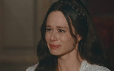 Atriz Mariana Ximenes olha para frente com cara de choro em cena de Nos Tempos do Imperador