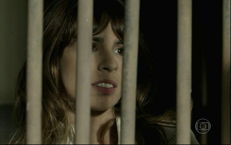 A atriz Maria Ribeiro atrás de grades em cena como Danielle em Império