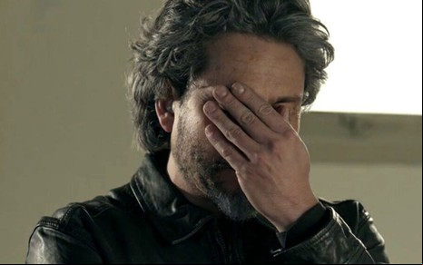 Alexandre Nero está com a mão no rosto em cena como José Alfredo de Império