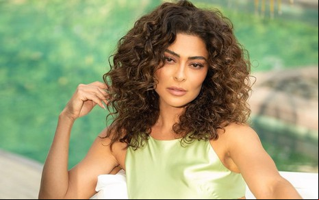 Juliana Paes posa com os cabelos soltos e cacheados, usando um vestido de cetim verde