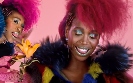 Com maquiagem exagerada e roupa bufante, Karol Conká mostra a língua e sorri em cena do clipe de Lalá