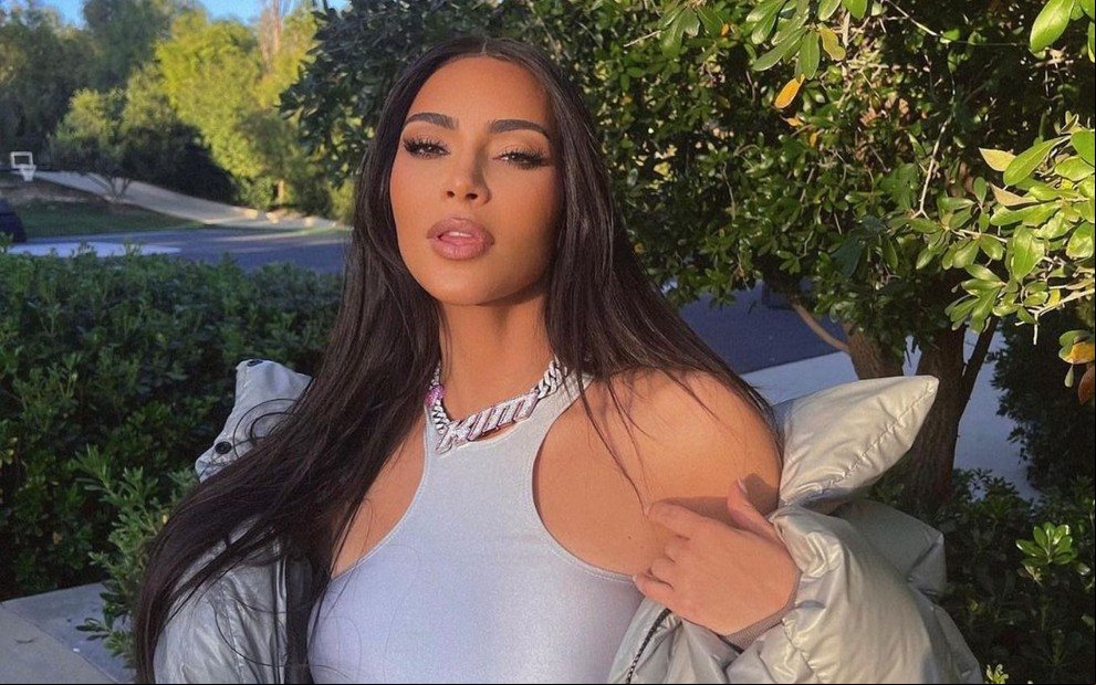 Kim posando em paisagem arborizada.