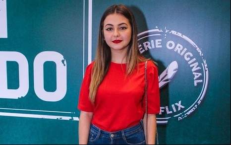 A atriz Klara Castanho usa blusa vermelha e calça jeans durante evento realizado em São Paulo em 2019