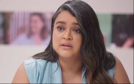 Foto de Preta Gil; ela está com cabelo solto e camisa regata azul