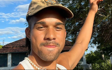 Lucas Leto está com o braço levantado nos bastidores da novela no Pantanal