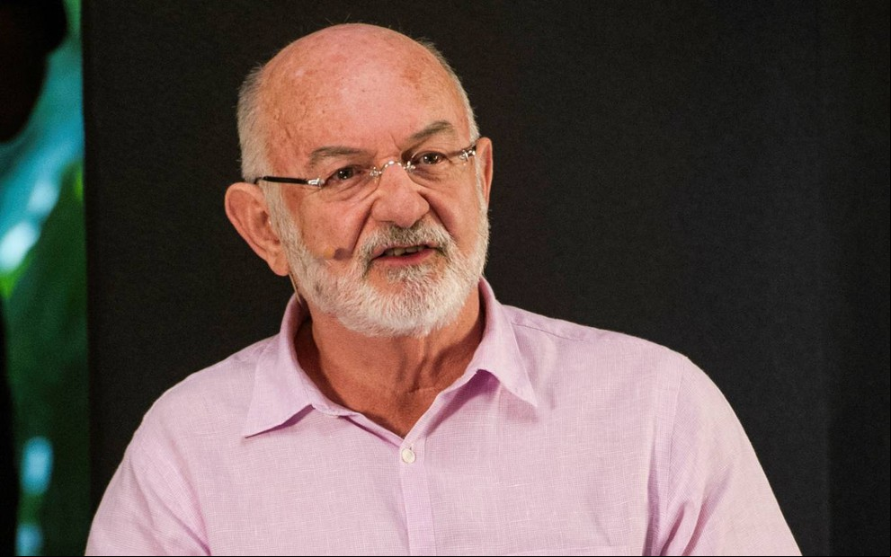 Silvio de Abreu usa camisa rosa e olha para frente em entrevista ao programa Ofício em Cena
