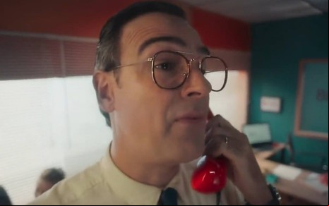 Foto mostra Tadeu Schmidt vestindo uma camiseta amarela e segurando um telefone