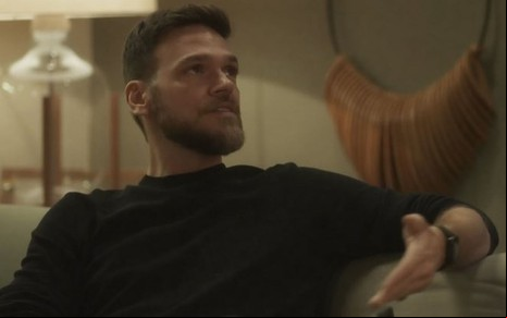 Em cena de Vai na Fé, Emilio Dantas está falando com alguém