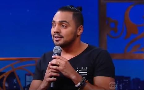Humorista Tirullipa com microfone em mãos no programa do SBT The Noite