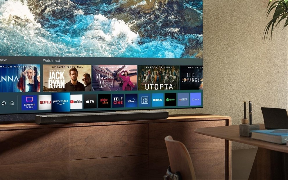 TV mostrando os vários aplicativos da plataforma Tizen em uma sala decorada