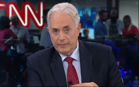 William Waack na CNN Brasil com um terno preto e uma gravata vermelha