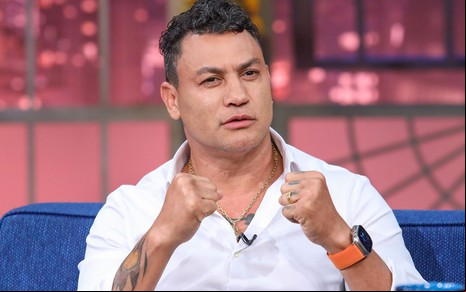 Popó cerrando os punhos no cenário do The Noite
