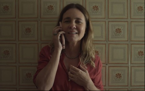 Adriana Esteves está no telefone e exprime aflição em cena de Os Outros