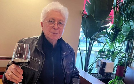 Aguinaldo Silva está com uma taça de vinho em um restaurante