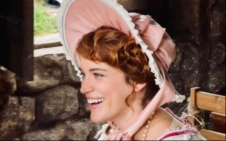 Bianca Bin sorri usando uma roupa rosa de época durante as gravações de Dona Beja