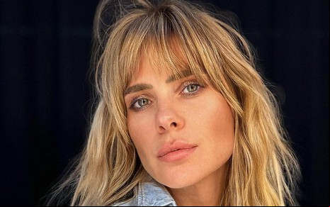 De franja e blusa jeans, Carolina Dieckmann posa para foto