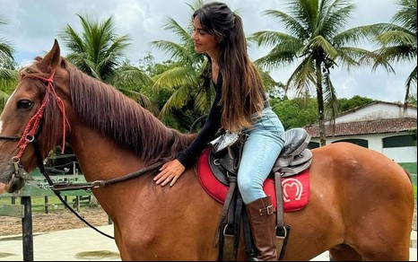 Giullia Buscacio está montada em cavalo durante aula de equitação