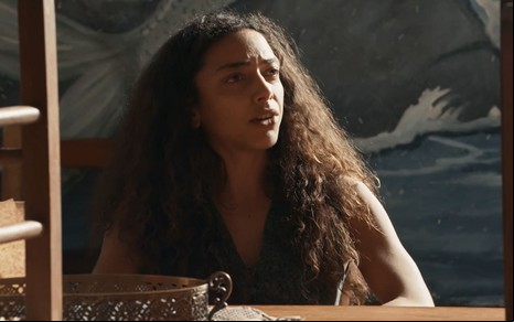 Alice Carvalho caracterizada como Joana; ela exprime choque em cena de Renascer