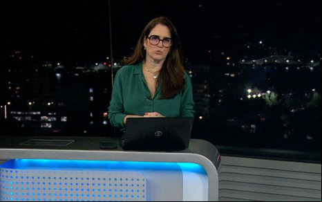 Ana Luíza Guimarães na bancada do RJ2 com o Jardim Botânico à noite de fundo