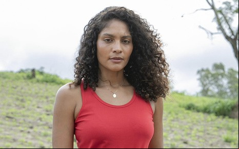A atriz Barbara Reis usa regata vermelha e posa em ambiente de fazenda da novela Terra e Paixão como Aline