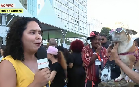 Priscilla Moraes olha torto para uma cachorra que usa óculos escuros