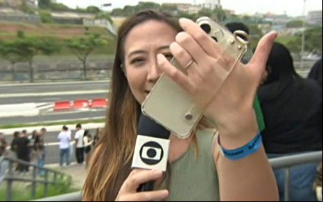 Juliane Massaoka mostrando celular em edição do É de Casa