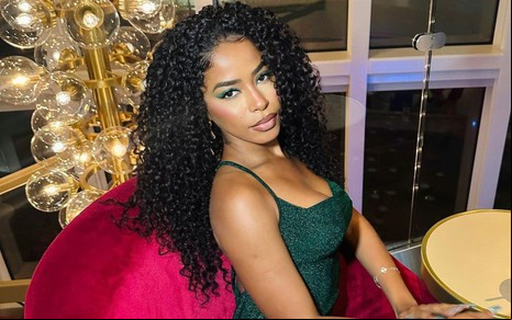Foto de Lorena Maria; ela está com o cabelo solto e usa vestido verde