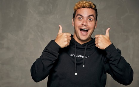 Luccas Netto sorri e mostra os dois dedos com os polegares erguidos