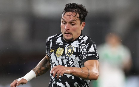 Artur veste uniforme preto e branco do Botafogo e faz movimento de correr com a bola em jogo no Brasileirão 2025