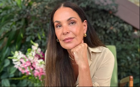 A atriz Carolina Ferraz com expressão séria, mão no queixo, posando para foto