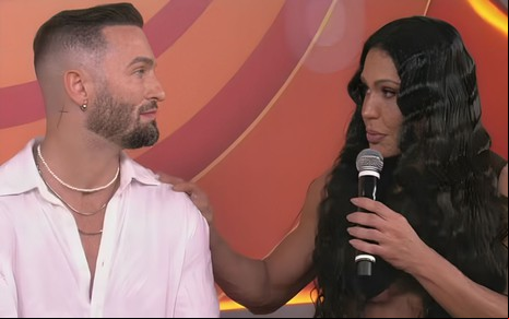 Diego Hypolito e Gracyanne Barbosa se entreolhando no Prêmio Gshow BBB 25, ela coloca a mão no ombro dele e segura um microfone