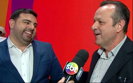 Foto mostra o apresentador Felipe Macedo e o diretor Mauro Lissoni durante coletiva