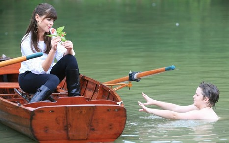 Alinne Moraes está tranquila em um barco no lago, enquanto um menino se afoga ao seu lado