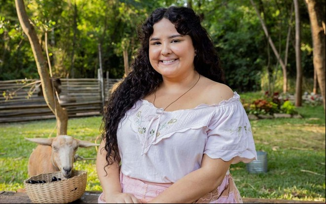 Castorine está caracterizada como Maria Divina, sua personagem em Êta Mundo Melhor!, da TV Globo